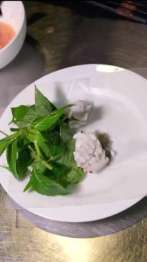 Deniz ürünleri tabağını şifalı otlarla düzenleyen eller. Yüksek kaliteli FullHD görüntüler