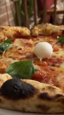 Margherita pizzalı, mozarella domatesli fesleğen bir restoranda duruyor. Dilimlenmiş yemek, yemek, çiçekler, kahve, romantizm, kadın eli kırmızı manikür olacak. Yüksek kalite 4k