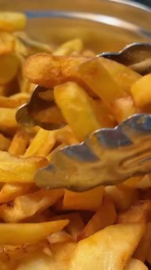 Patates kızartma şefleri maşa servis ederken konteynırdan altın rengi patates kızartmalarını alıp shawarma, donör kebap ya da ayrı ayrı bir malzeme olarak eklerler. Fast food, fast food restoranı.