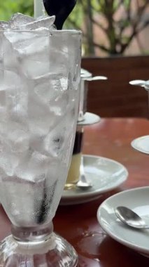 Geleneksel Vietnam kahve damlası filtresi mermer bir masaya konmuş turuncu bir fincan tabağı ile bir bardağa konur. Görüntü demleme sürecini yakalar. Yüksek kalite 4k görüntü