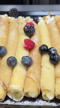 Tereyağlı karamelli soslu elma ve kuru üzümle dolu ince Fransız gözlemesi bir tüpe sarılmış. Pudra şekeri serp ve naneyle süsle. Bir dizi video tarifinin bir parçası..