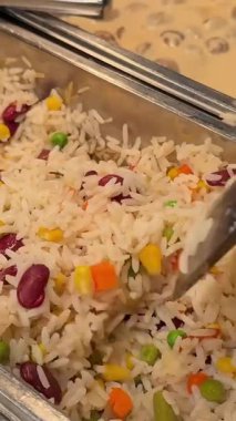 Açık büfedeki tavuklu pilav ve lezzetli salatadan dökülen pirinç ve sebze karışımı. Yakın plan. Yüksek kalite 4k görüntü