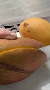  Elle dilimlenmiş bir mango meyve küpünü bıçakla yakın plan, tropikal meyve. Mango video eğitiminin nasıl kesileceğini. sağlıklı konsept yemek. Yüksek kalite 4k görüntü