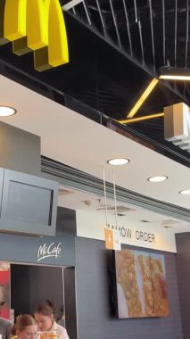 Face McDonalds fast food restoranı abur cuburlar bar alışveriş merkezi, şehirdeki McDonalds tabela satıcılarını bekleyen gerçek hayat. Polonya Katowice 03.22.2025
