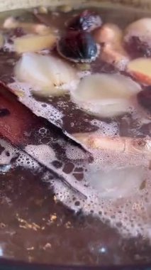 Sıcak tencere aşçısı fa pho soup vietnam yakın plan kızartıcı tavada et suyu pişirilmiş domuz kemikleri kız Vietnam 'da yemek pişirmek için bir restoran büfesinde yemeğini karıştırıyor. 4k görüntü
