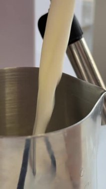 Kahveci sütü sürahiyle çırpıyor. sürahi sütlü kapuçino makinesi.