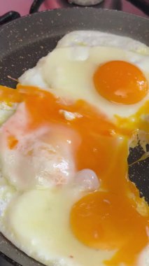 Güneşli tarafı ters çevirme girişimi başarısız oldu. Kızartma tavasından spatulayla bir yumurta al.