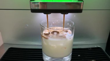 Buzlu kahve hazırlama, kahve makinesinden buz küplerine kahve doldurma şeffaf bardakta soğuk demleme kahvesi yapma. Yüksek kalite 4k görüntü