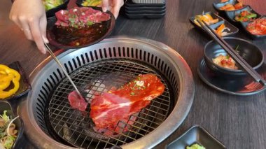 Kore-Japon Barbekü Restoran Büfesi 'nde Kızarmış Et, Yemek Pişirme, Öğle Yemeği İnce Dilimler, Siyah Masa' da Izgara Et. Yüksek kalite 4k görüntü