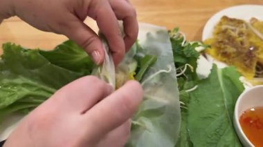 Kadın elleri çırpılmış yumurtaları sebzeyle sarar. Lezzetli sağlıklı yiyecekler. Yeşillik, vejetaryen, Asya restoranı sosa batırılır. Yüksek kalite 4k görüntü