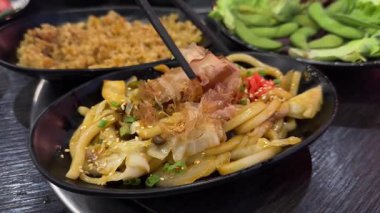 Bir kase Asya Japon eriştesi ve acı soslu siyah tabak restoranındaki fasulye. Yüksek kalite 4k görüntü