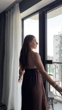 Portekiz 'in Porto şehrinde güneşli bir günde genç bir kadın büyük bir pencere perdesi açar. Kadın mutlu ve neşeli, kumaşı iterek açtıktan sonra gün ışığının içeri girmesinden hoşlanıyor. Sessiz ve huzurlu sabah güneşi