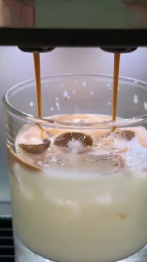 Buzlu kahve hazırlama, kahve makinesinden buz küplerine kahve doldurma şeffaf bardakta soğuk demleme kahvesi yapma. Yüksek kalite 4k görüntü