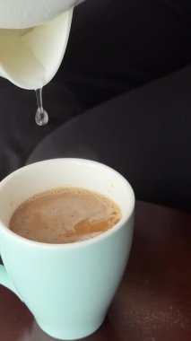 Kahve fincanını dolduruyorum. Taze koyu kahve. Beyaz fincana dökülüyor. Köpüklü kahve. Sabahları sıcak kahve. Yüksek kalite 4k görüntü