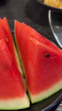 Sulu kırmızı karpuz, açık büfe meyveli bir restoranda, siyah bir masanın üstünde duruyor. Yüksek kalite 4k görüntü