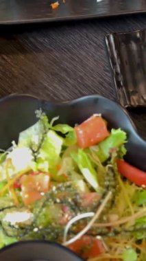 Masa siyah metali, Asya mutfağı salataları, suşi baharatları deniz ürünleri sebzeleri ve Japon restoranının açık büfe ziyafeti gibi ağır çekimler sundu. Yüksek kalite 4k görüntü