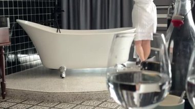 Temiz su kavramı arka plandaki sağlıklı yaşam tarzı kızı ön plandaki temiz su bardaklarıyla pencereyi eğerek sağlık için su içme ihtiyacı duyuyor. Yüksek kalite 4k görüntü