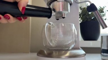 Espresso makinesi aydınlık bir sabahta modern mutfakta kahve yapar. Yüksek kalite 4k görüntü