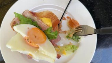 Ton balıklı sandviç, taze sebze salatası, haşlanmış yumurta ve mavi tabakta peynir ile besleyici ev yapımı kahvaltı. Sıcak sabah atmosferi, temiz yemek. Yumurtalı kruvasan