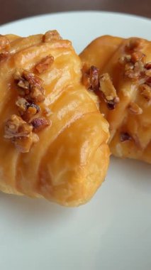 Lezzetli karamelli kruvasan beyaz tabak kafe restoranında iki dilim taze hamur işi tatlı kahvaltı unu. Yüksek kalite 4k görüntü