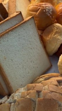 Yiyecek ve içecek amaçlı video formatında dokuma sepetinde çeşitli ekmekler sergileniyor. Yüksek kalite 4k görüntü