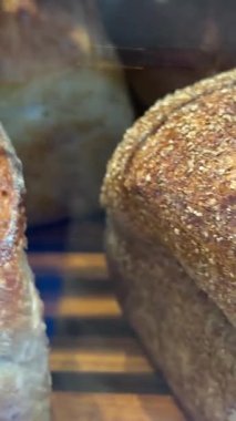 Ahşap masada farklı türde taze ekmek. Kahverengi arka planda münferit bir ekmek çeşidi. Kaypak Teal ve Orange 'ı vuruyor. Yüksek kalite 4k görüntü