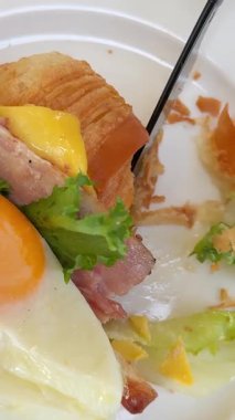 Ton balıklı sandviç, taze sebze salatası, haşlanmış yumurta ve mavi tabakta peynir ile besleyici ev yapımı kahvaltı. Sıcak sabah atmosferi, temiz yemek. Yumurtalı kruvasan