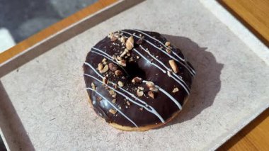 Fındık parçacıklı çikolatalı çörek. Makro. Sağlıksız yiyecekler. Fırın ve yemek konsepti. Şekerli jöleli donut. Kaydırıcı atışı. Yakın plan. Yüksek kalite 4k görüntü