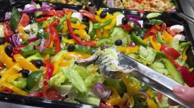 Büfede taze malzemeler ve yenilebilir çiçeklerle güzel bir şekilde sunulmuş gurme salataları. Yüksek kalite 4k görüntü