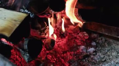 Izgarada yanan odun kömürleri. Siyah arka planda ateşli kıvılcımlar. Yavaş hareketler. Yakacak odun közleri