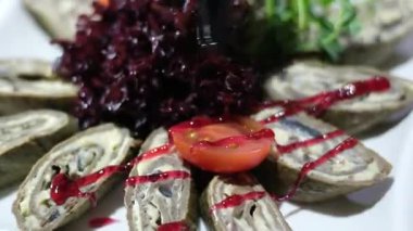 Ispanak ve peynir rulosu, pancar ve otlarla doldurulmuş sos, domates dilimleri ve Slav mutfağının olduğu beyaz kare bir tabakta servis ediliyor. Yüksek kalite 4k görüntü