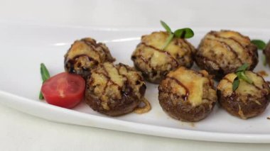 Fırından doğruca tabağa doldurulmuş mantar servisi. Doldurulmuş peynirli şampiyonlar