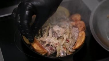 Kızarmış soğanlı krema ile sıcak patates pişirme süreci kızartma tavasında bir tabak üzerine çok lezzetli Slav Ukrayna yemeği serpiştirip sarımsaklı iştah açıcı sıcak kızartma tavası serpiyor. 4k görüntü