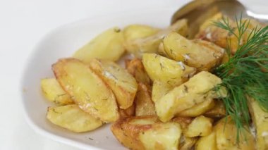 Kırsal tarzda kızarmış patates, baharatlar, biberiye ve ahşap bir masada taze domatesler, fırından fırına yakın patates kızartması.