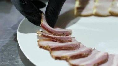 Fransız ekmeğiyle dilimlenmiş domuz pastırması. Sosis retro-stil yemek tepsisinde ve yemek kağıdında. Yavaş çekim kaydırağın üzerinde. Taze marul yaprakları da kullanıyoruz. Yüksek kalite 