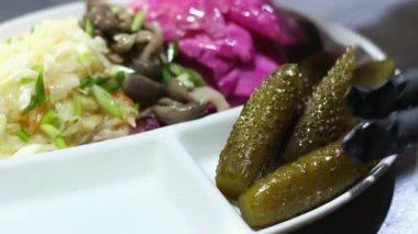Aşçı beyaz bir tabakta salatalık turşusu ve siyah eldiven servis eder. Yüksek kalite 4k görüntü