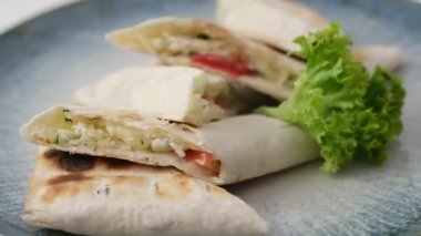 Taze sebze ve beyaz arka planda tavuk dürümü yanında doğranmış domates ve yeşillik. Peynirli ve domatesli lavaş.