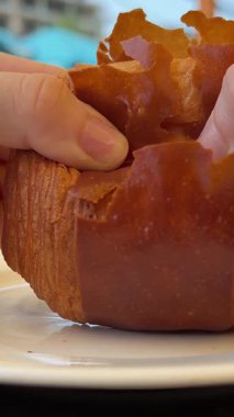 Kadın elleri, çikolatalı kruvasan ve puf böreklerinin yapısını incelerken bir börek kırar. Yüksek kalite 4k görüntü