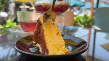 San Sebastian peynirli keki ya da yanmış peynirli kek denen popüler İspanyol tatlısıyla yemek. Yavaş çekim 4K görüntüsü. Yüksek kalite 4k görüntü