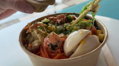 Karides, pirinç, avokado, mango, edamame fasulyesi, ahşap zemin üzerinde salatalık. Sağlıklı yemek, keto diyeti konsepti. Poke kasesi, geleneksel Hawaii çiğ balık salatası. Asya çiğ yemeği. Yüksek