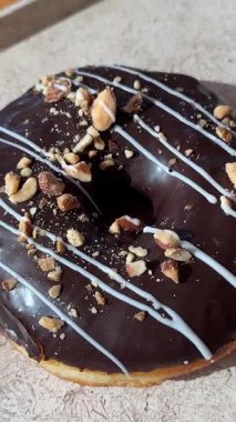 Fındık parçacıklı çikolatalı çörek. Makro. Sağlıksız yiyecekler. Fırın ve yemek konsepti. Şekerli jöleli donut. Kaydırıcı atışı. Yakın plan. Yüksek kalite 4k görüntü