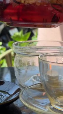 Bar Cheesecake 'in yanındaki Black Table' da bir sokak restoranında cam fincana bitki çayı dökülüyor. Yüksek kalite 4k görüntü