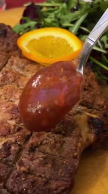 Taze pişmiş biftek üzerine fesleğen sosu ve beyaz tabakta ızgara sebze. Yüksek kalite 4k görüntü