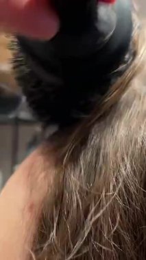 Stüdyodaki kuaför kadın müşterinin saçını saç kurutma makinesiyle kurutuyor. Profesyonel kuaför kuaförde saç stili yaratır. Usta müşterilerin saçlarıyla ilgilenir..