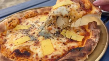 Sıcak peynirli pizza. Bir dilim iştah açıcı pizza servis edilirken taze Margarita peyniri eriyor. Yüksek kalite 4k görüntü