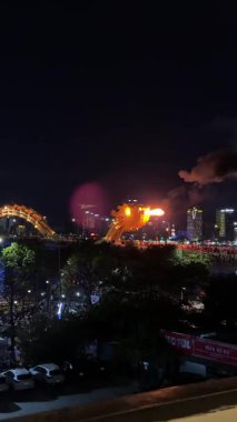 İkonik ejderha köprüsü Cau Rong 'un inanılmaz renkli yakın çekimi, trafik ve şehir silüeti Danang, Vietnam' da gece. Yüksek kalite 4k görüntü