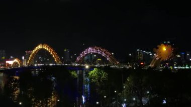 İkonik ejderha köprüsü Cau Rong 'un inanılmaz renkli yakın çekimi, trafik ve şehir silüeti Danang, Vietnam' da gece. Yüksek kalite 4k görüntü