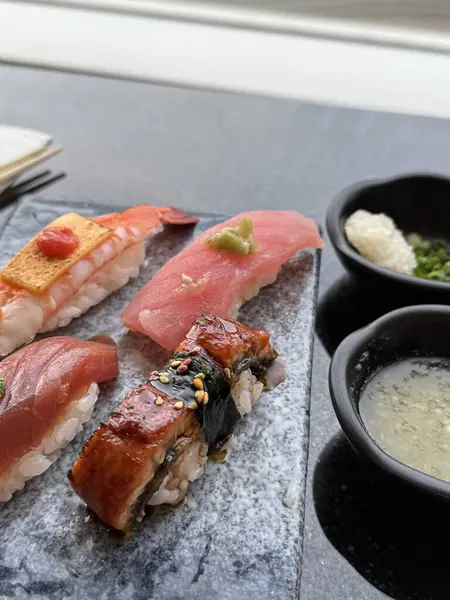 Lux Roll. Siyah arka planda suşi kompozisyonu. Japon Mutfağı Sanatı. Menü ve suşi bar dekorasyonu için yemek fotoğrafçılığı. Yüksek kalite fotoğraf