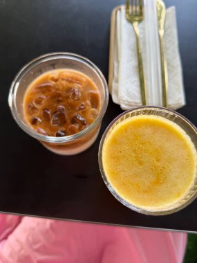 Dikey fotoğraf. iki tane Vietnam kahvesi, konsantre süt ve portakal suyu.