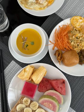 Dikey fotoğraf kahvaltı meyve çorbası. Kabak çorbası havuç pirinç Vietnam turtası meyveli karpuz ve fıstık ezmeli muzlu sandviç.